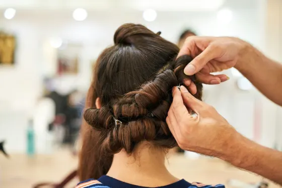 Stylist setting hair in rollers