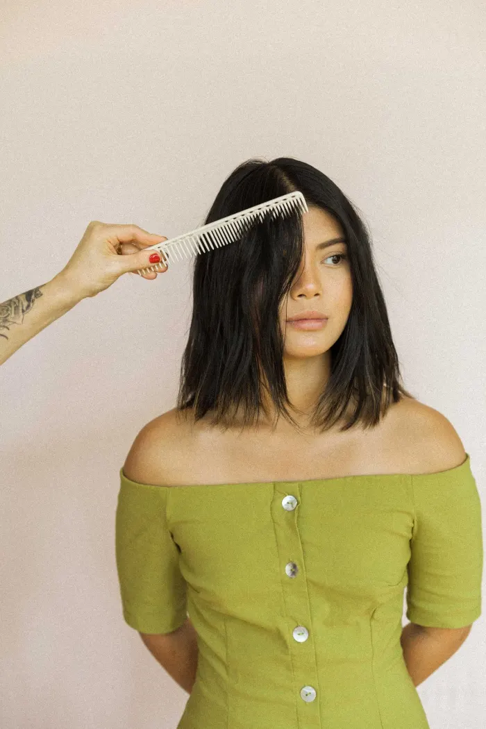 Stylist combing a model's fresh bob